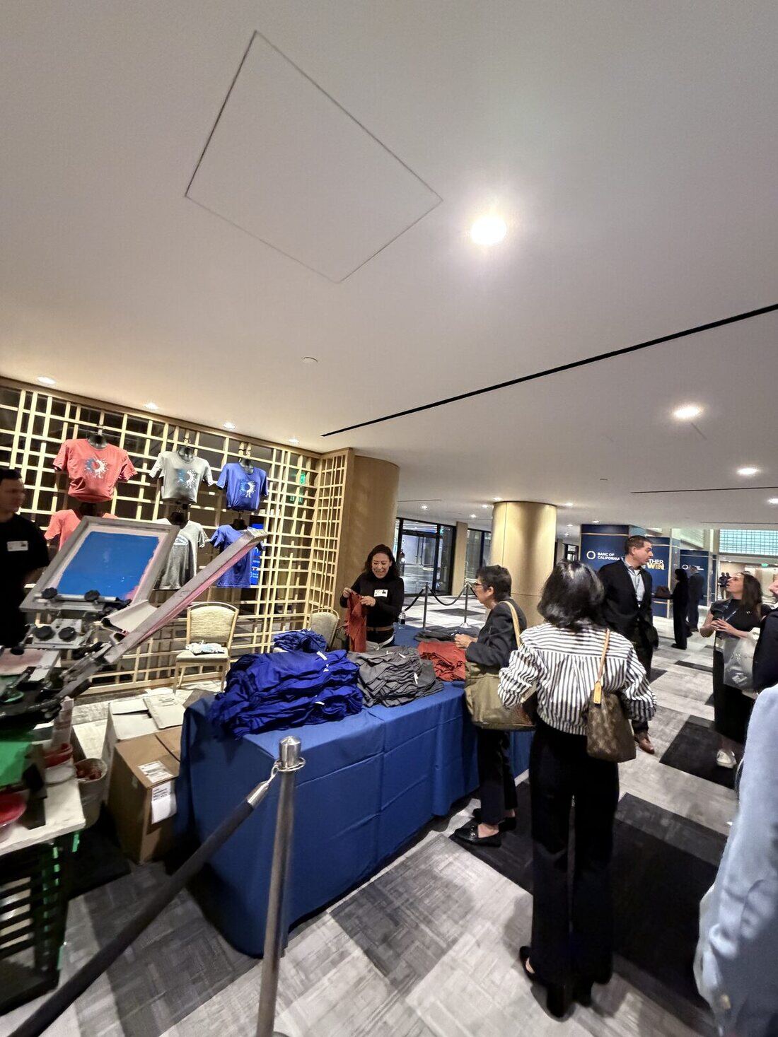 Guests lined up at a rented merch booth waiting for live-printed apparel
