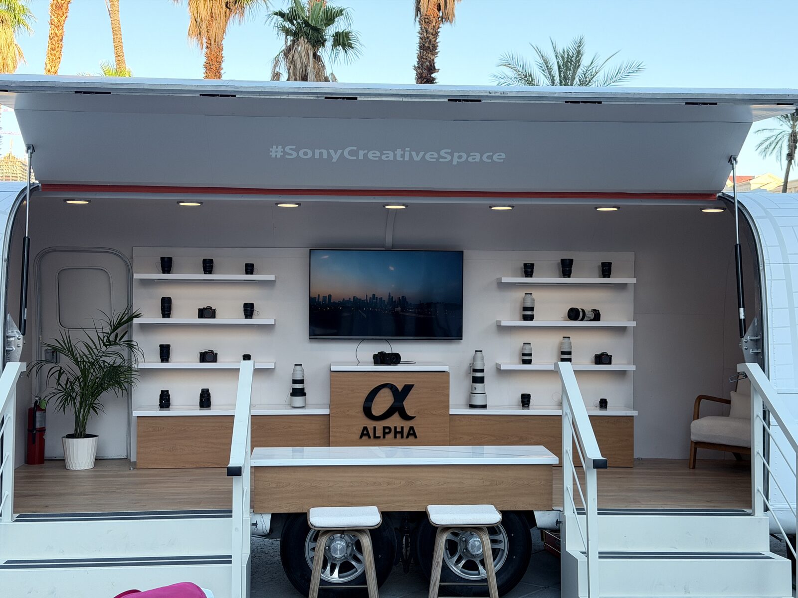 Outdoor event booth with a printing trailer at a festival